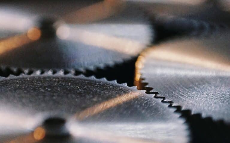 Close-up image of interlocking metal gears with sharp teeth, highlighting fine details and textures—an ideal representation for industrial gearbox rebuild or emergency gearbox repair services. The gears’ circular shapes and metallic surfaces are sharply in focus.