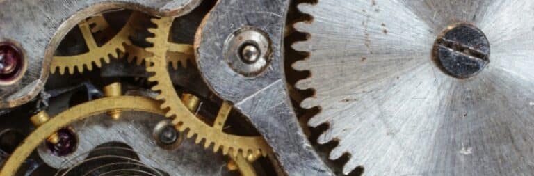 Close-up of interlocking brass and steel gears inside a mechanical device, highlighting intricate details and metallic textures—perfect for showcasing industrial gearbox rebuild expertise.